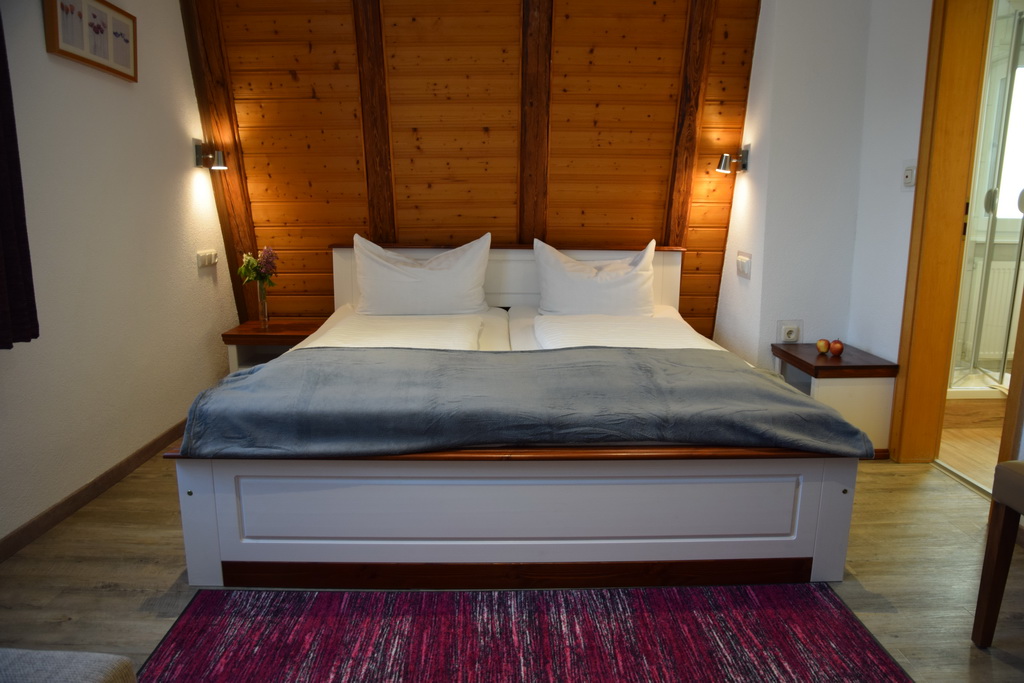 Bett vor Holzwand